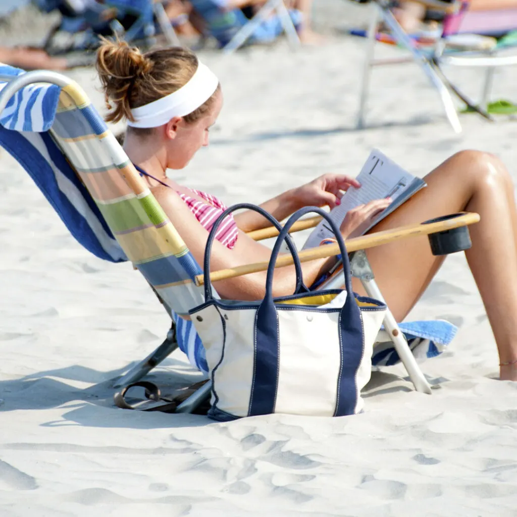 Woman on the beach reading a mystery novel.