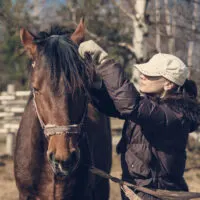 A woman trimming a horse mane.