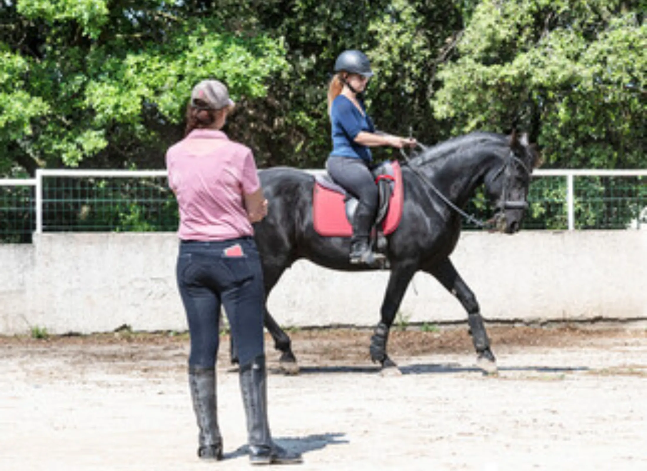 Photo of a child on a horse in a horseback riding lesson.