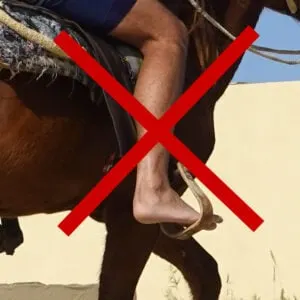 A person riding a horse barefoot, with red x over image.